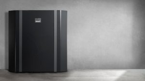 A TermoPlus industrial heat pump against a grey wall.